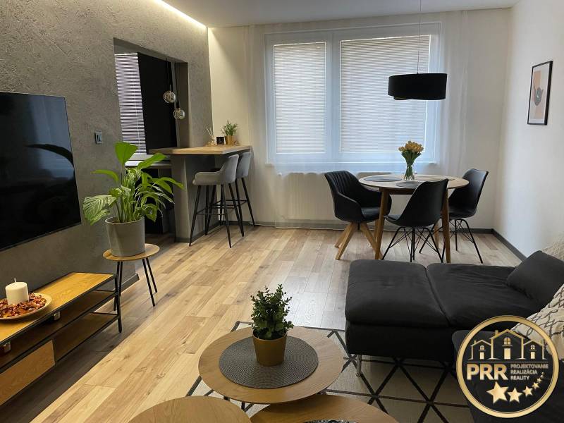Wohnzimmer in einer 3-Zimmer-Wohnung mit Sofa, Esstisch und Fernseher.