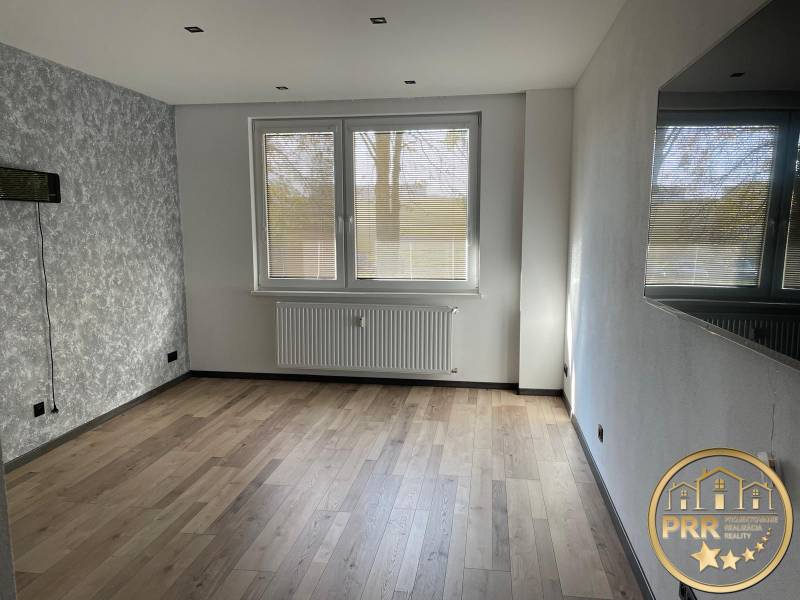 Wohnzimmer in einer 3-Zimmer-Wohnung mit grauen Wänden und hellen Böden.