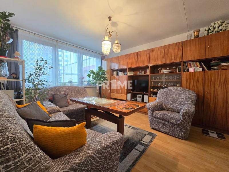 Wohnzimmer einer 3-Zimmer-Wohnung in der Bárdošova-Straße, eingerichtet mit bequemen Möbeln und Holzschränken.