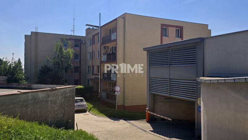 Ein Wohnhaus in der Bárdošova-Straße in Bratislava, Kramáre, umgeben von Grünflächen und einem Parkplatz.