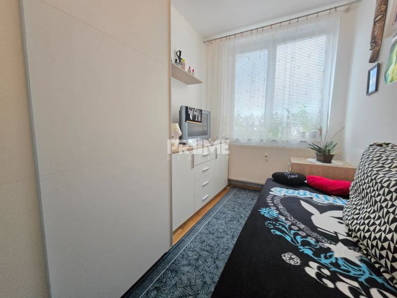 Ein Zimmer in einer 3-Zimmer-Wohnung in der Bárdošova-Straße mit Möbeln, einem Fenster und Dekorationen.