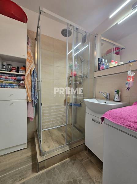 Badezimmer mit Dusche und Waschbecken in einer 3-Zimmer-Wohnung.