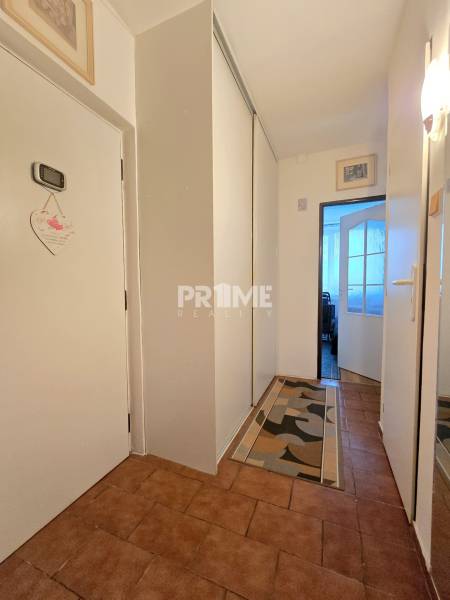 Flur mit Einbauschränken und Keramikfliesen in einer 3-Zimmer-Wohnung.