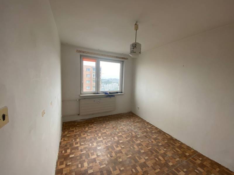 Ein Zimmer in einer 3-Zimmer-Wohnung mit Holzboden und einem Fenster mit Aussicht.
