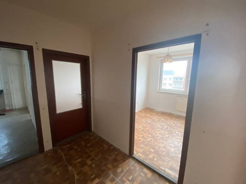 Flur in einer 3-Zimmer-Wohnung mit Holztüren und Holzboden.