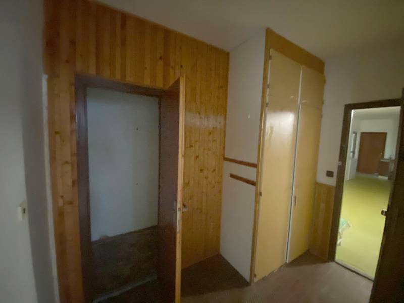 Flur mit Holzvertäfelung und Einbauschrank in einer 3-Zimmer-Wohnung.