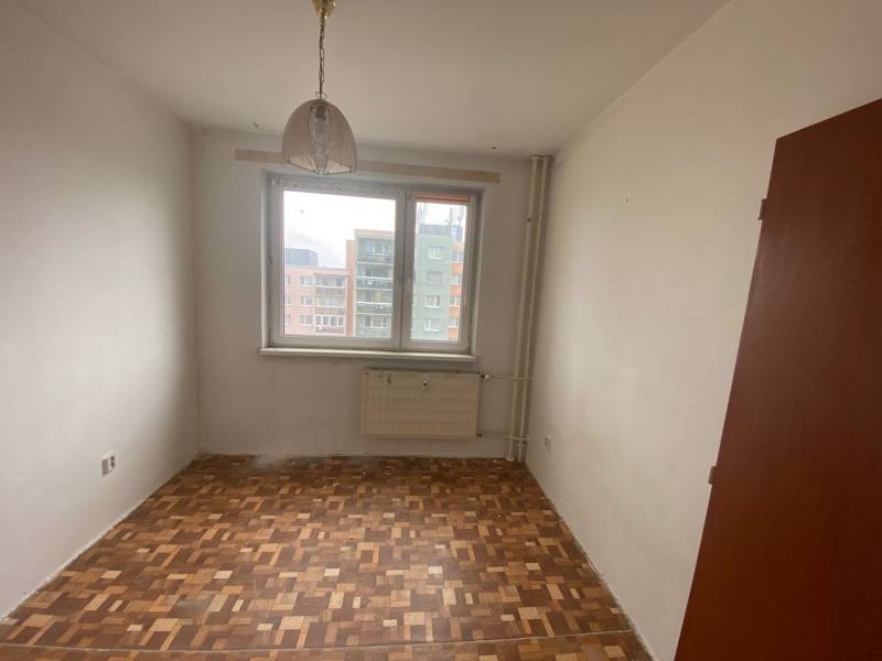 Ein Zimmer mit Parkettboden und einem Heizkörper in einer 3-Zimmer-Wohnung.