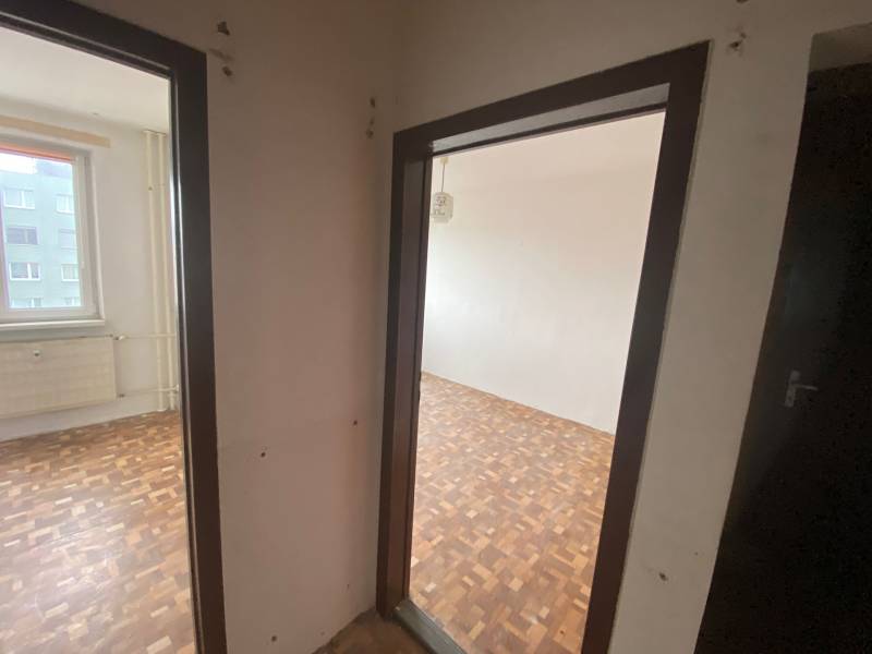 Flur in einer 3-Zimmer-Wohnung, Parkettboden, Zugang zu zwei Räumen, Fenster mit Aussicht.