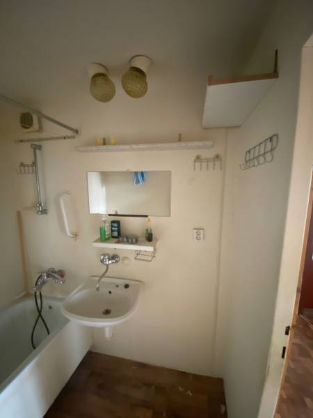Badezimmer mit Badewanne und Waschbecken in einer 3-Zimmer-Wohnung mit Ablagefächern.