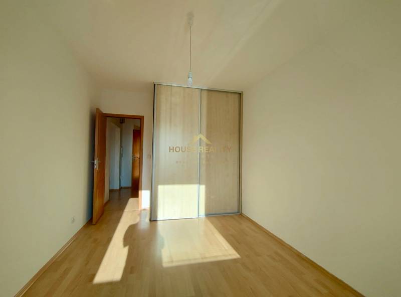 Ein Zimmer in einer 3-Zimmer-Wohnung mit einem Boden in Holzoptik und einem Einbauschrank.