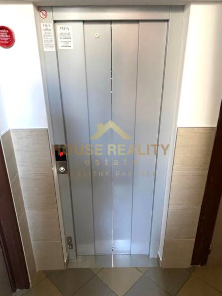 Aufzug in einer 3-Zimmer-Wohnung mit dem Logo einer Immobilienagentur an der Tür.