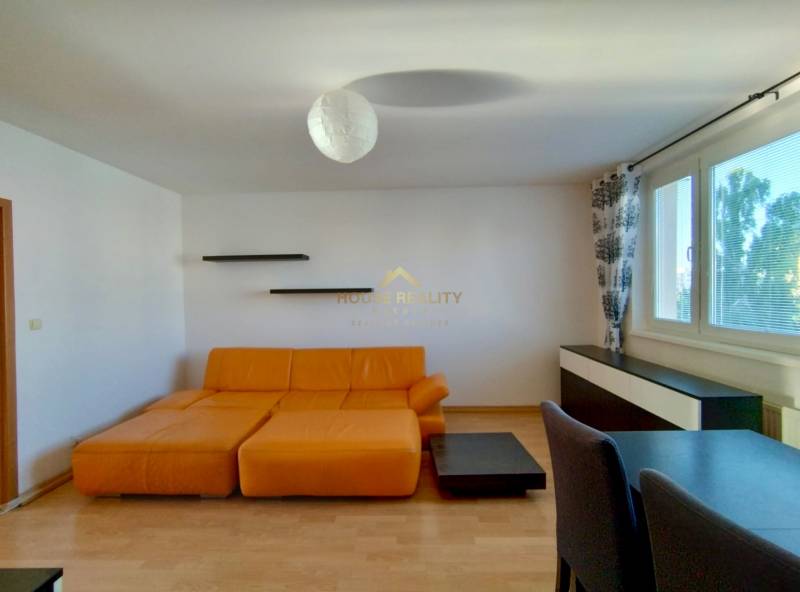 Wohnzimmer mit Sofa und Boden in Holzoptik in einer 3-Zimmer-Wohnung.
