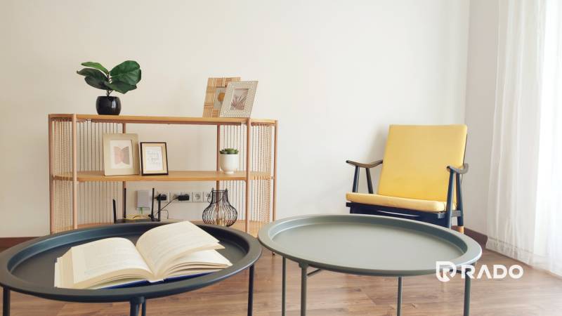 Innenraum einer 2-Zimmer-Wohnung mit dekorativen Elementen, einem Stuhl und einem Tisch mit einem Buch.