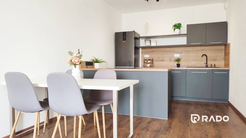 Küche mit Esstisch und Stühlen, 2-Zimmer-Wohnung mit Holzboden und Dekoration.