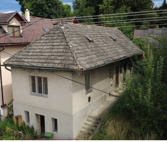 Ein Einfamilienhaus unter dem Bôd Bánoš in Banská Bystrica mit einem schrägen Dach und einem Garten.