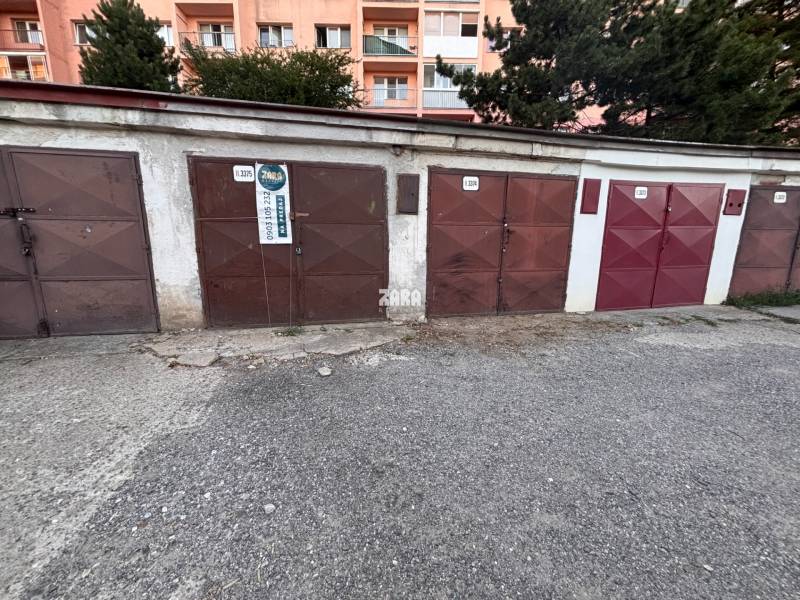 Garagen in der Považská-Straße, Košice - Stadtteil Západ mit einem Wohnblock im Hintergrund.