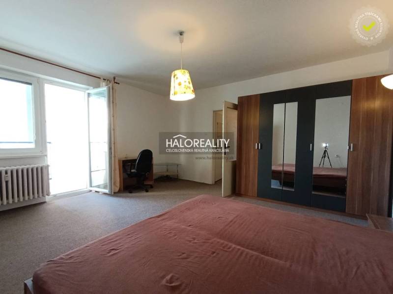 Geräumiges Zimmer in einer Einzimmerwohnung mit Bett, Schrank und Balkontüren.