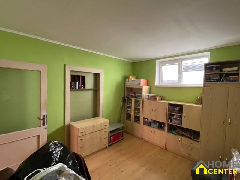 Ein Zimmer in einem Einfamilienhaus mit Holzmöbeln und grünen Wänden.