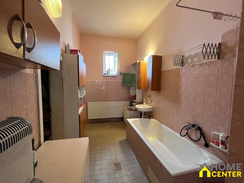 Ein Badezimmer in einem Einfamilienhaus mit Badewanne, Waschbecken und Schränken, gemütliche Einrichtung.
