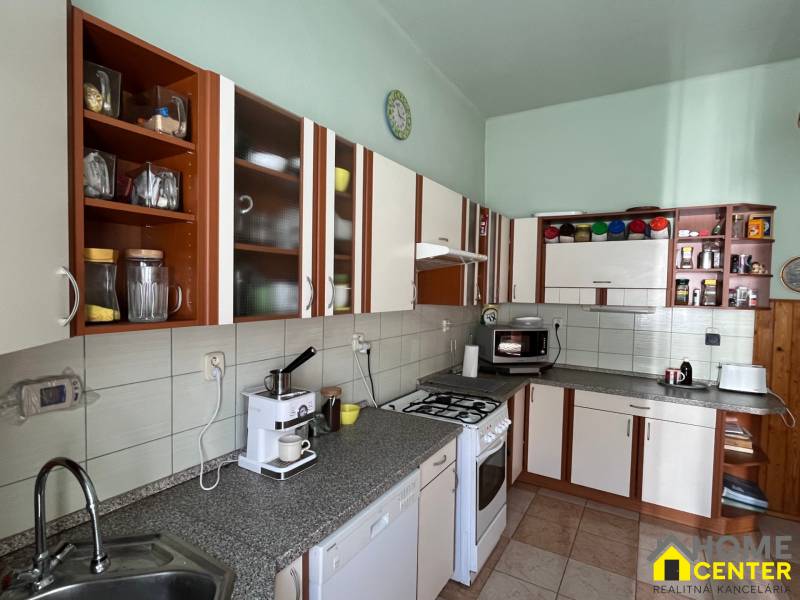 Eine Küche in einem Einfamilienhaus mit braunen und weißen Schränken und einer Kaffeemaschine.