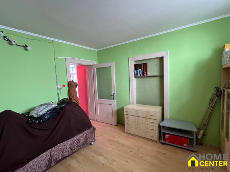 Ein Zimmer in einem Einfamilienhaus mit Holzmöbeln und grünen Wänden.
