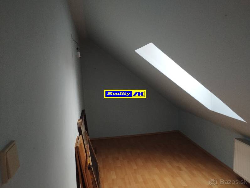 Dachzimmer mit Holzboden und Dachfenster in einem Einfamilienhaus.