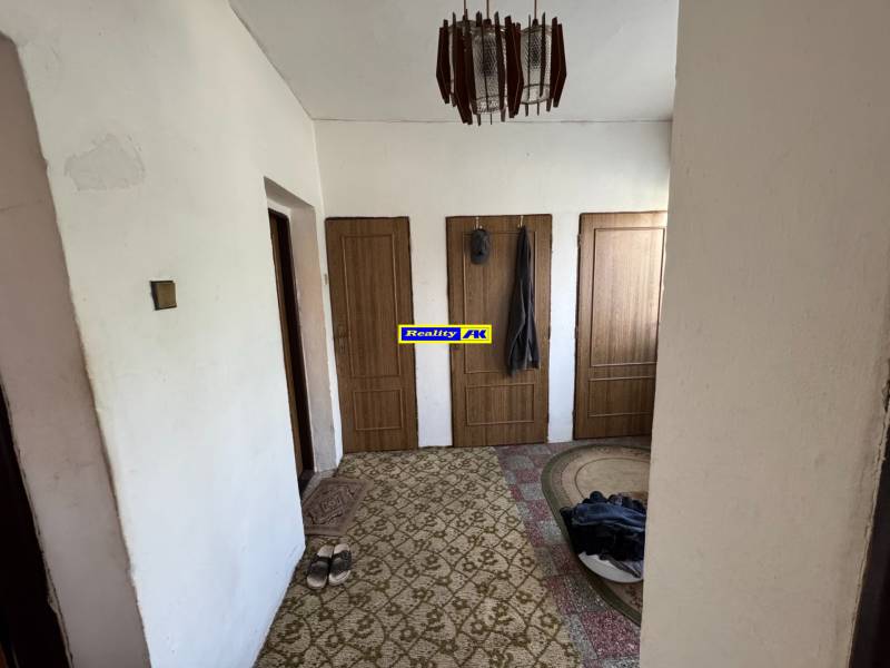 Ein Interieur mit drei Türen, einem Teppich, einer Lampe, Schuhen, Einfamilienhaus.