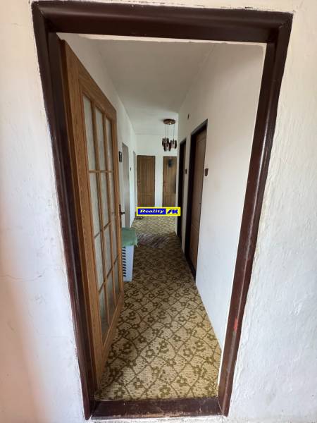 Flur in einem Einfamilienhaus mit Teppichboden und Holztüren.
