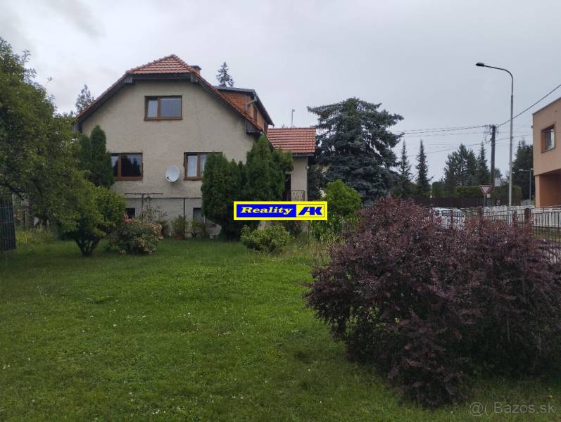 Ein Einfamilienhaus in Martin, mit einem gepflegten Garten und umgeben von Bäumen und Sträuchern.