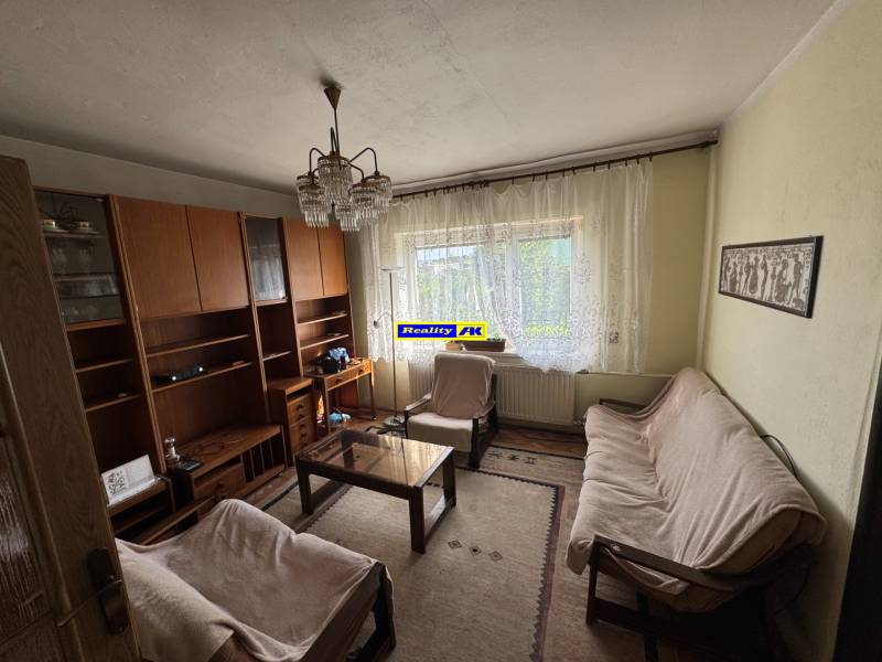 Wohnzimmer in einem Einfamilienhaus mit Sofa, Teppich, Wand mit Schränken.