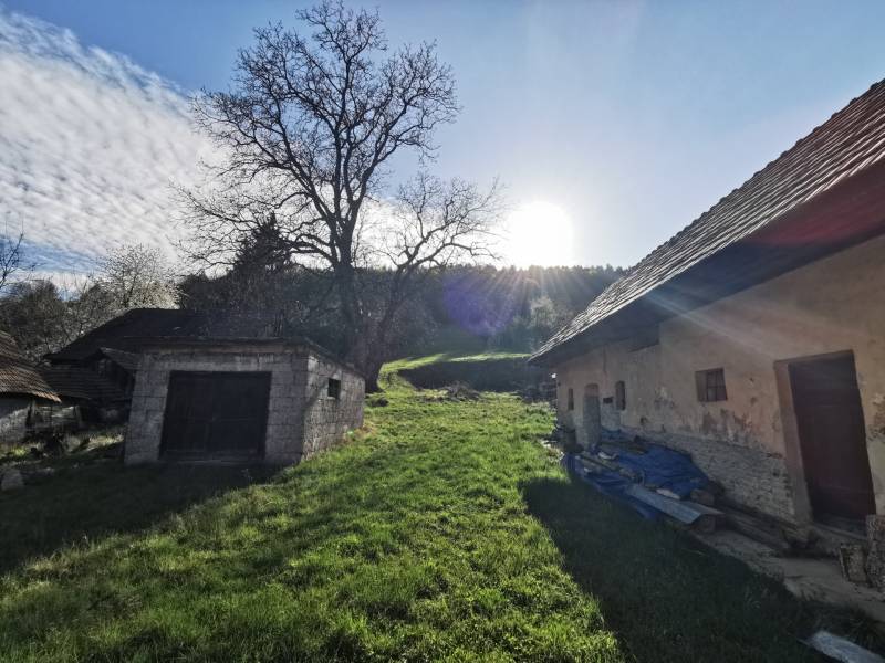 Ein Grundstück mit Rasen, einem Einfamilienhaus und einer alten Garage in der Nitrianska-Straße in Nitrianske Sučany.
