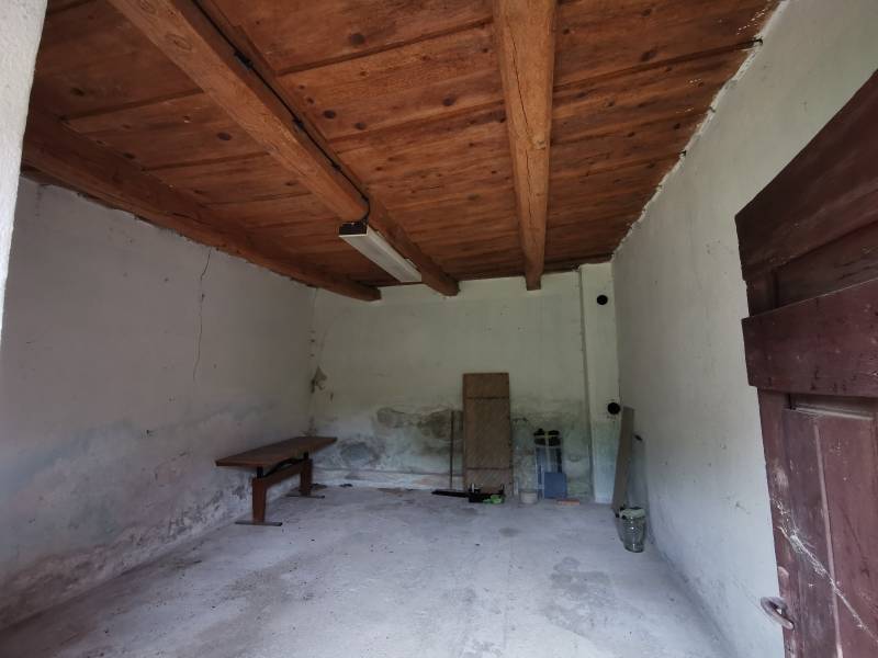 Die Holzdecke im Raum eines Einfamilienhauses mit einfacher Einrichtung und weißen Wänden.