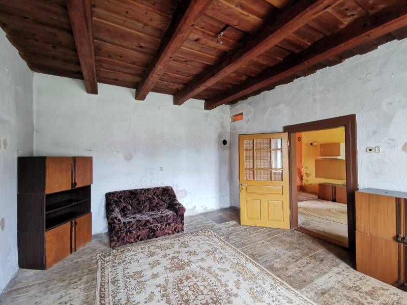 Ein Zimmer mit einer Holzdecke und Retro-Möbeln in einem Einfamilienhaus.