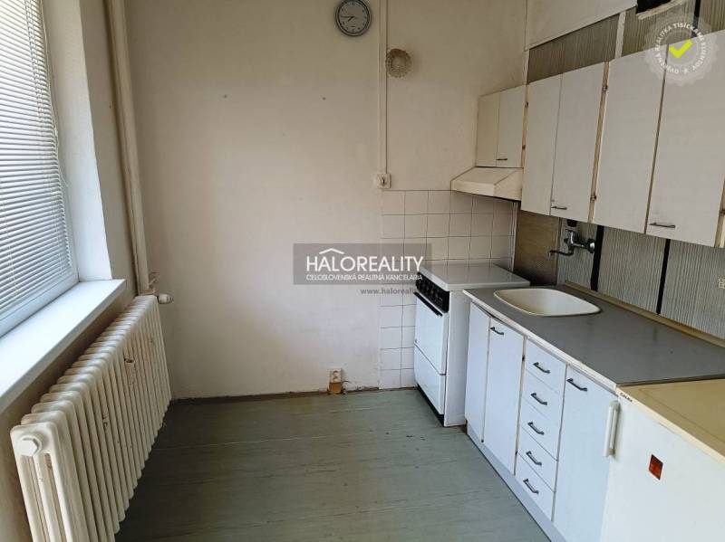 Küche in einer Einzimmerwohnung mit Herd, Spüle und Küchenschränken.
