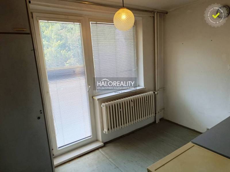 Innenraum einer Einzimmerwohnung mit Jalousien am Fenster und Hängelampe.