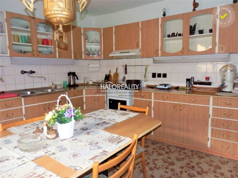 Eine Küche in einem Einfamilienhaus mit einer Holzarbeitsplatte, einem Esstisch und Blumendekoration.