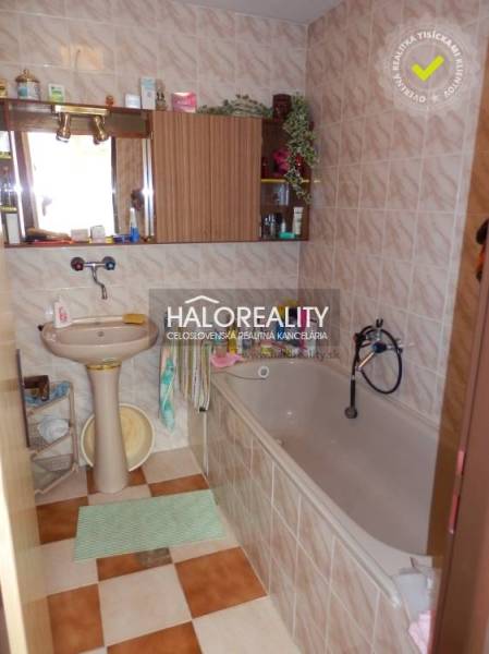 Badezimmer in einem Einfamilienhaus mit Badewanne, Waschbecken und Spiegel.