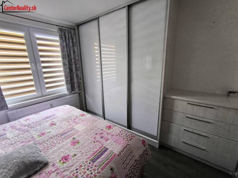 Schlafzimmer mit Einbauschrank und Blumenüberwurf in einer 3-Zimmer-Wohnung.