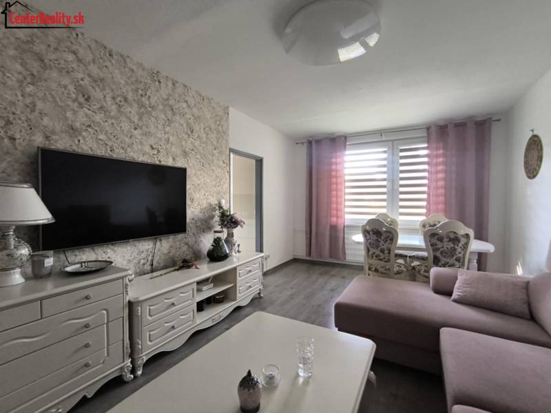 Wohnzimmer in einer 3-Zimmer-Wohnung mit Fernseher, Sofa und Esstisch.