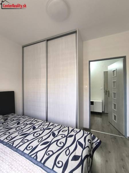 Schlafzimmer mit Schiebetürenschrank und Bett in einer 3-Zimmer-Wohnung.