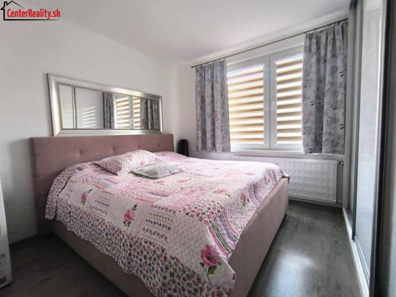 Schlafzimmer in einer 3-Zimmer-Wohnung mit einem großen Bett und einer Blumenüberdecke.