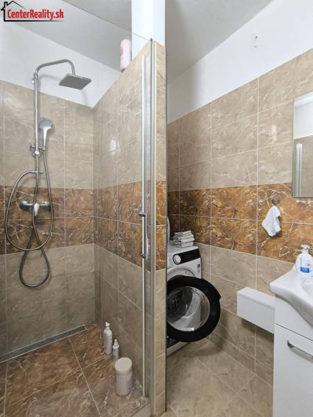Badezimmer mit Dusche und Waschmaschine in einer 3-Zimmer-Wohnung.