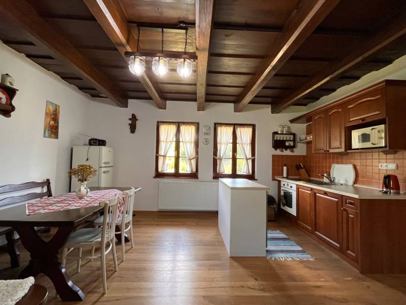 Küche in einem Einfamilienhaus mit Holzdecke, stilvollem Esszimmer und Herd.
