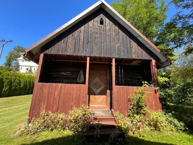 Ein Holzfamilienhaus in Vagrinec, umgeben von Rasen und Grünflächen.