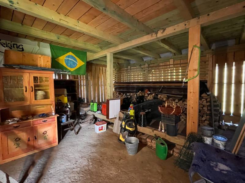 Das Innere einer Garage in einem Einfamilienhaus mit verschiedenen Werkzeugen und einer brasilianischen Flagge an der Wand.