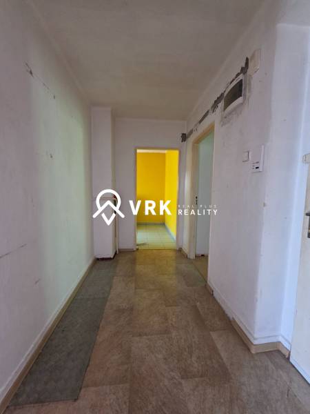 Der Flur in einer 2-Zimmer-Wohnung mit einem sichtbaren Raum in Gelb.