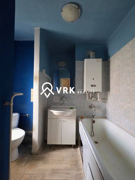 Badezimmer in einer 2-Zimmer-Wohnung mit Badewanne, Waschbecken und Toilette, die Farbtöne der Wände sind blau.