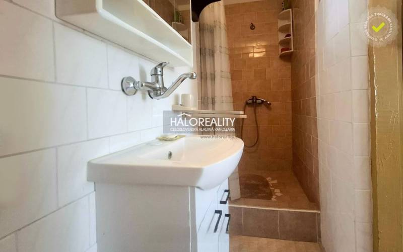 Badezimmer mit Waschbecken und Duschkabine im Einfamilienhaus.