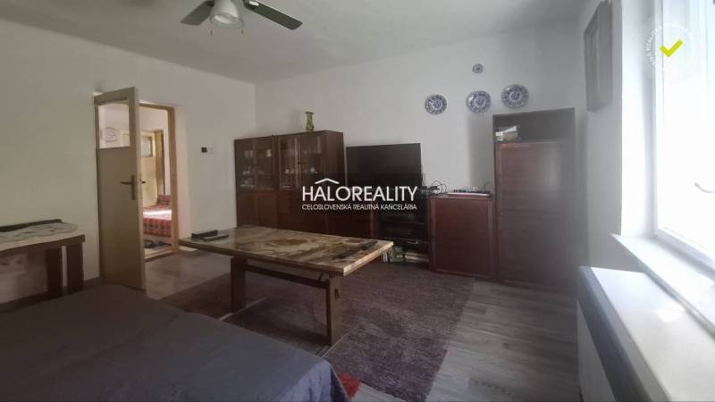 Wohnzimmer in einem Einfamilienhaus mit Möbeln und Fernseher, helle Wände.