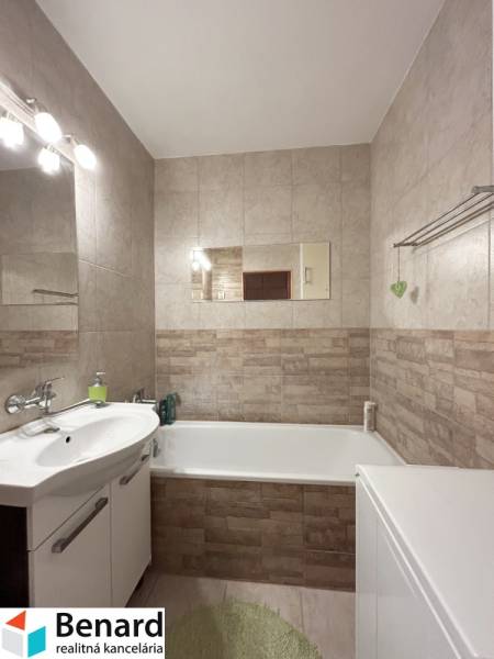Badezimmer in einer 2-Zimmer-Wohnung mit Badewanne, Spiegel und Toilettenschrank.